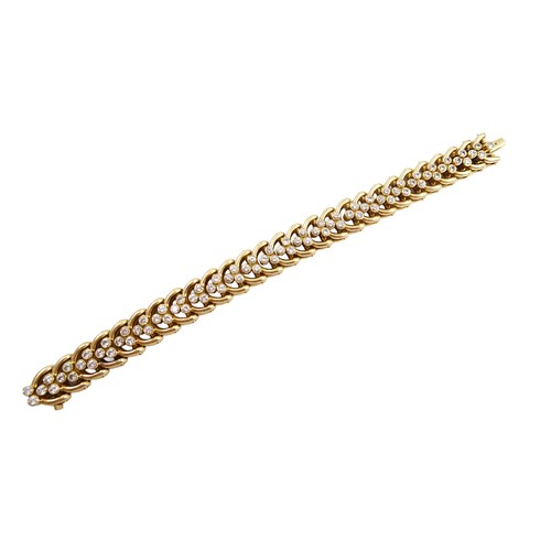 Gold and diamond scroll link bracelet by Cartier, formed of a row of looped C scrolls with triple diamond clusters,